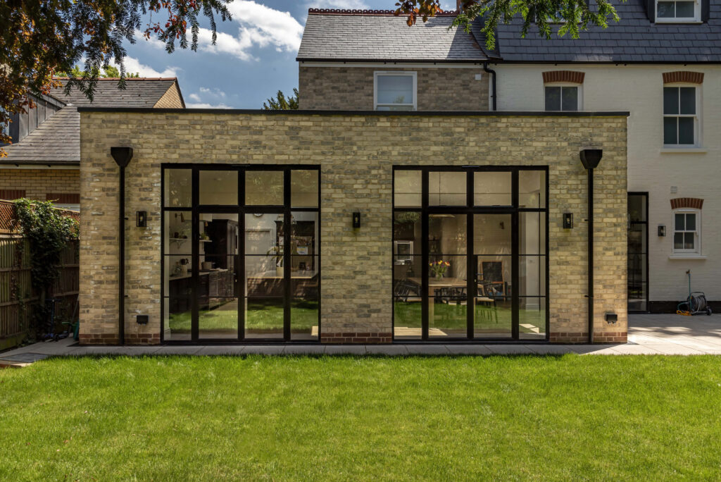 Aluco steel-look French doors in a new brick extension on the back of a large house