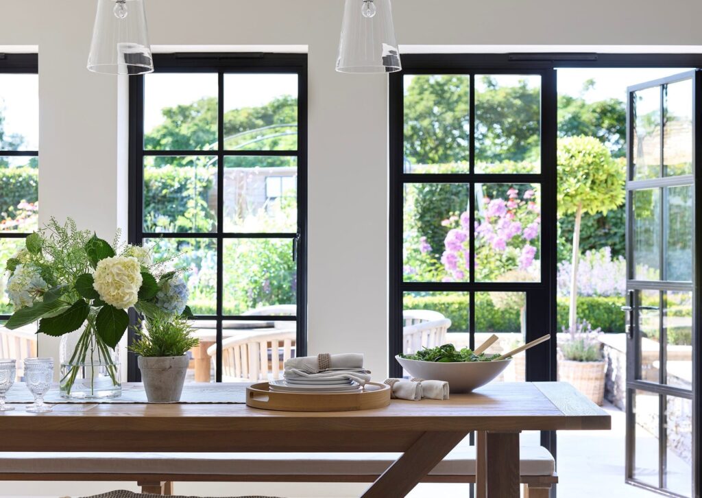 dining room with steel look open patio doors and windows dining table in foreground