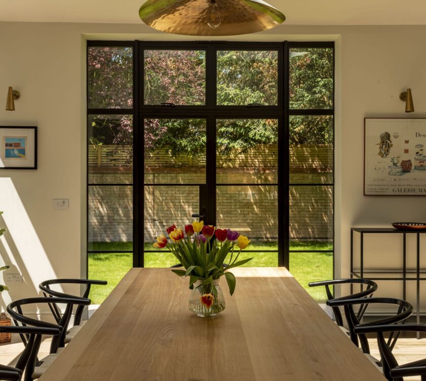 picture of kitchen patio doors in the steel look design, black colour with dining table in foreground
